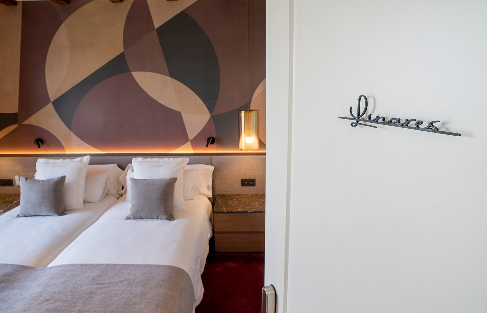 Suite Linarés con mural geométrico y su nombre en hierro