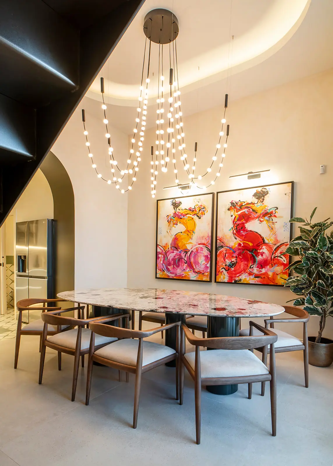 Comedor con lámpara de cristal y obra de Adrián Santo