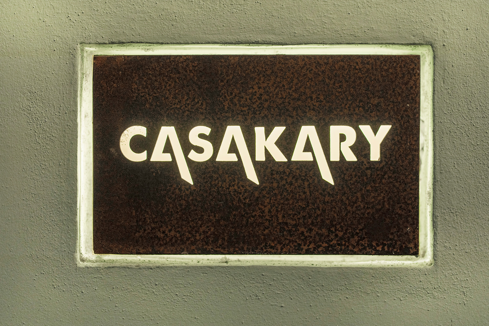 Placa de acero con el nombre CasaKary en la fachada