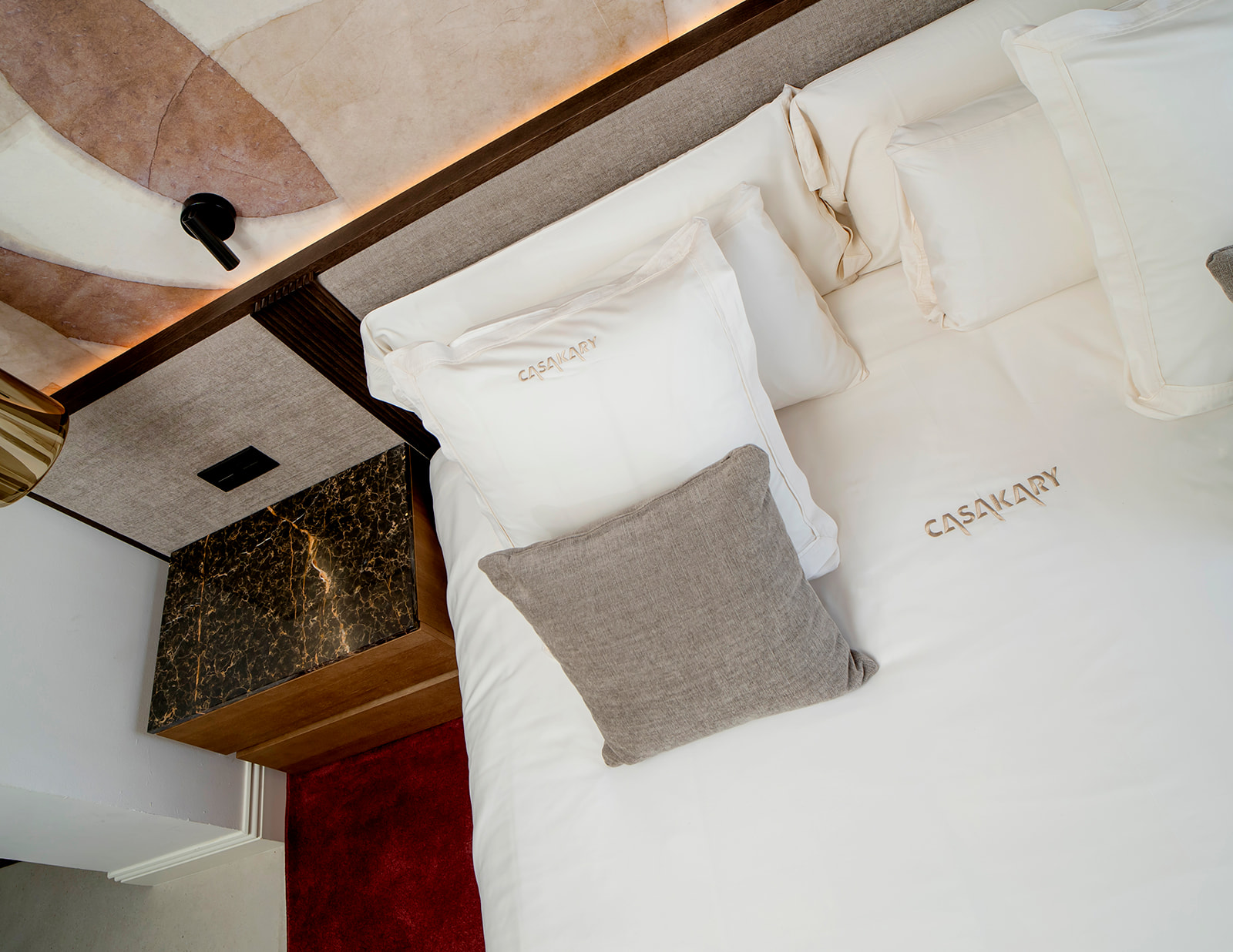 Cama vista desde arriba con ropa de cama bordada CasaKary