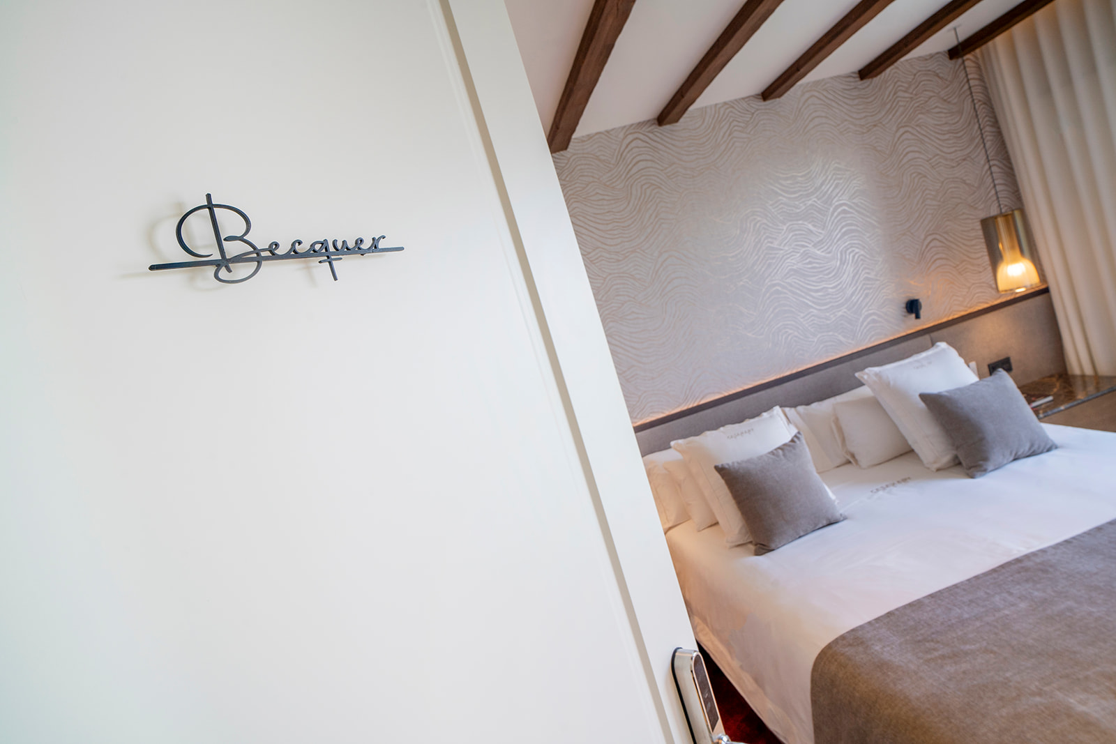 Entrada de la suite Bécquer con su nombre en hierro y la cama al fondo