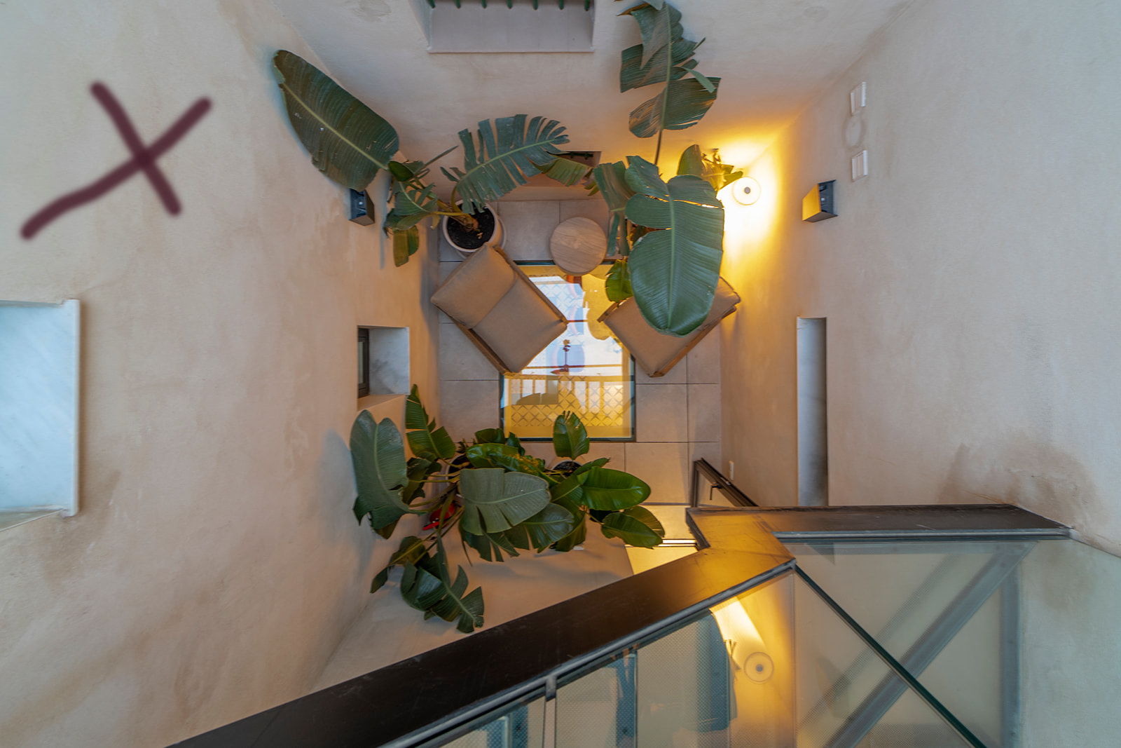 Hueco de escalera con plantas y cruz de hierro